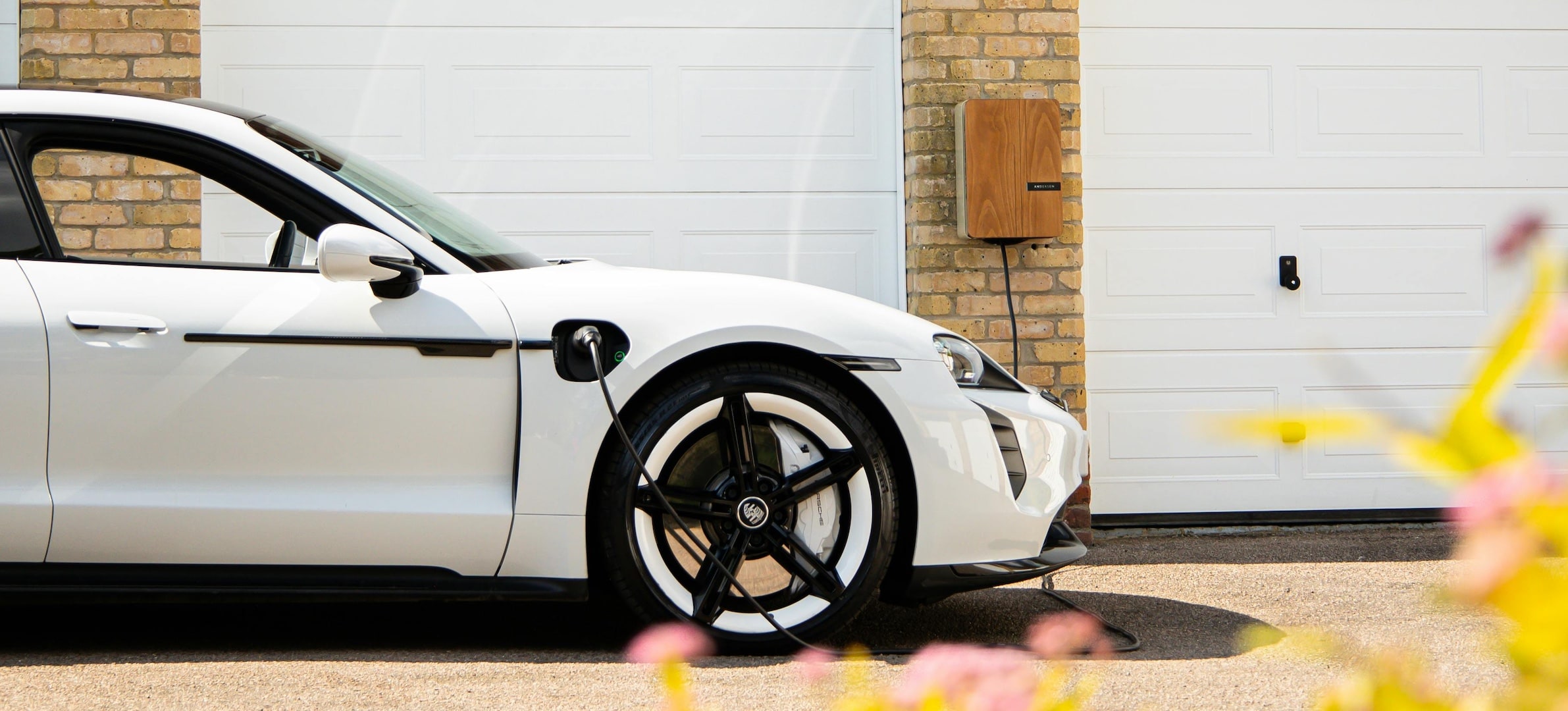 Home EV charging point on a UK driveway with solar integration, highlighting smart-charging savings